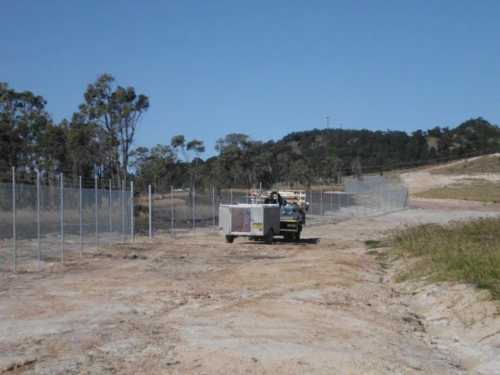A 1.8 m galvanised chainwire fence topped with three strands of barbed wire.