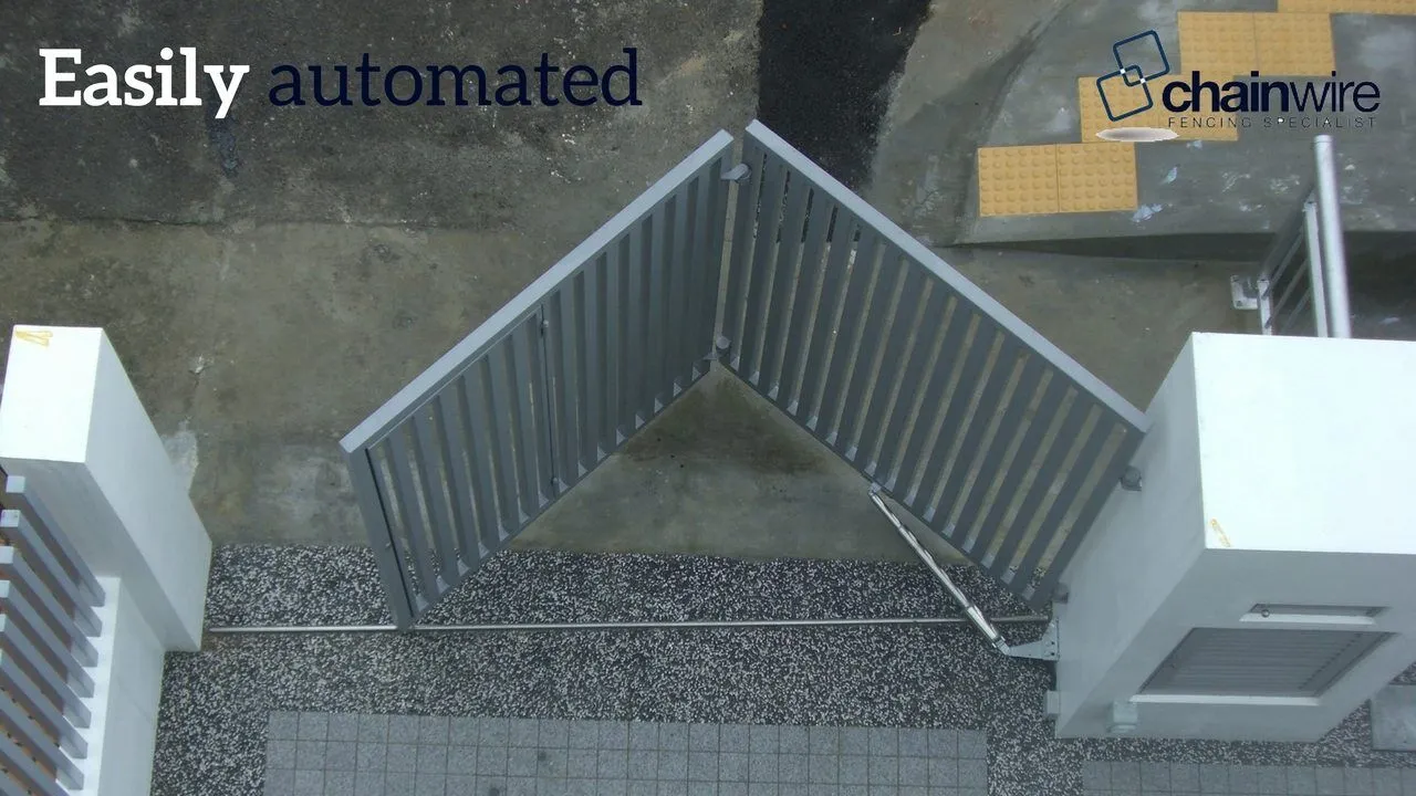 An automated swinging bi-fold gate folding open across a driveway