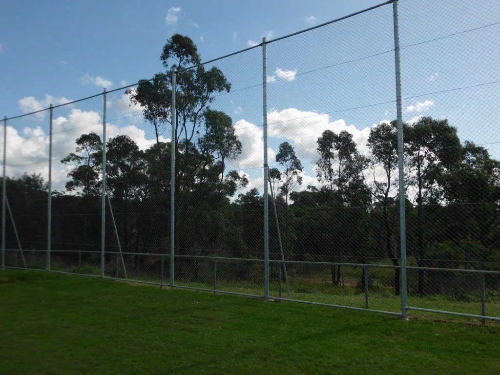 A 6 m high chainwire ball-stop screen with top and bottom rails behind a sporting field.