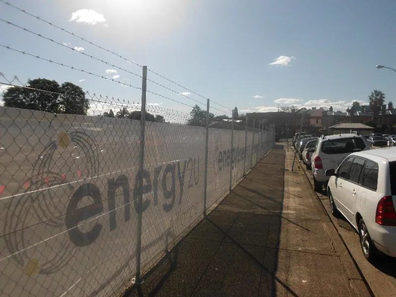 Construction site fencing with banner mesh screening along a street frontage