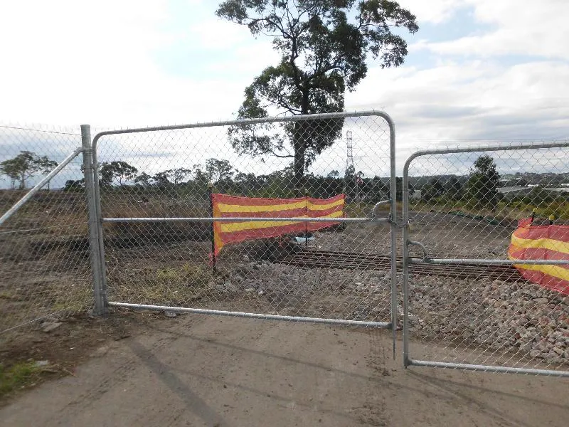 Temporary chainwire construction site fencing with lockable gates around a building site
