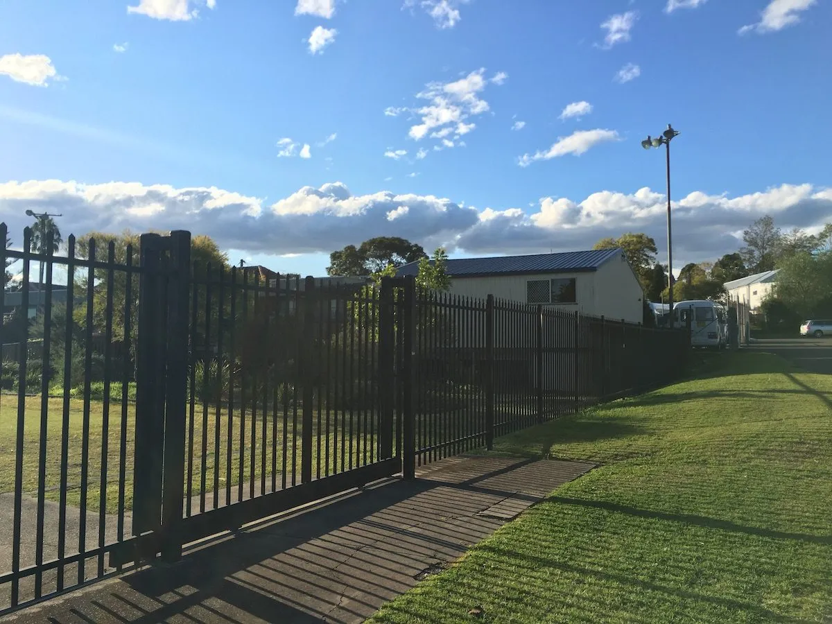 Black steel spear-top fence and gate at a sportsground